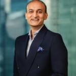 Business professional in formal suit smiling, representing trade finance expertise.