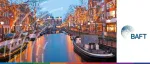 Dusk view of a scenic canal in Amsterdam with traditional Dutch houses and trees illuminated by warm festive lights for the BAFT 2025 Europe Bank-to-Bank Forum.