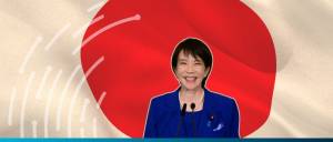 Sanae Takaichi with the Japanese flag behind her as background