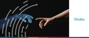 Close-up of a human hand reaching toward a glowing, wireframe AI hand, showing agentic AI in specialty insurance workflows.