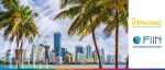 Bright daytime view of the Miami coastal skyline and high-rise buildings framed by palm trees for the ABS East conference, organized by Invisso and the Fixed Income Investor Network (FIIN).