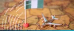 A miniature Nigerian flag and toy airplane on a map of Africa to illustrate the Afreximbank $1.1 billion crude oil prepayment facility for Nigeria.