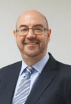 Trade finance professional smiling in formal attire.