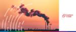 Industrial pollution emissions from factory smokestacks at sunset.