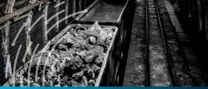 Mining train carrying rocks along railway tracks for mineral transportation.