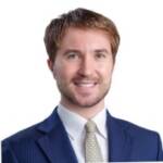 Professional businessman in a suit smiling, representing trade finance expertise.