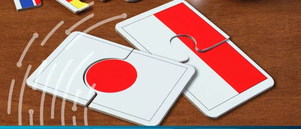Two puzzle pieces featuring the flags of Japan and Indonesia joining together on a wooden surface, representing diplomatic relations and BRICS membership.