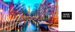 Dusk view of a traditional canal in Amsterdam featuring historic narrow houses, moored boats, and the Zuiderkerk tower for the Money 20/20 Europe fintech conference.