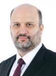 Professional portrait of a trade finance expert in formal attire.