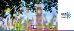 Daytime view of the Elizabeth Tower (Big Ben) and the Palace of Westminster framed by purple flowers and green foliage for the ICC United Kingdom Sustainability Conference.