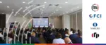 A panel of financial experts discussing global trade and the four corners model at an event featuring ITFA, FCI, EBRD, and TFP logos.