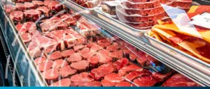 Fresh meat products displayed in a supermarket refrigerated case, highlighting import trends and foo.