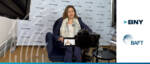 Woman speaking at trade finance event with BNY and BAFT logos.