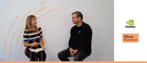 This image shows an interview setting at the Sibos Frankfurt conference. On the left, a woman with blonde hair, wearing a black and white striped off-the-shoulder top, sits holding a notebook and pen as she speaks. On the right, a man with short greyish hair, wearing a black shirt, sits facing her, engaged in the conversation. They are positioned against a minimalist white background featuring a subtle orange abstract line graphic. To the right of the pair, the NVIDIA logo and a "Sibos Frankfurt" text box are prominently displayed.