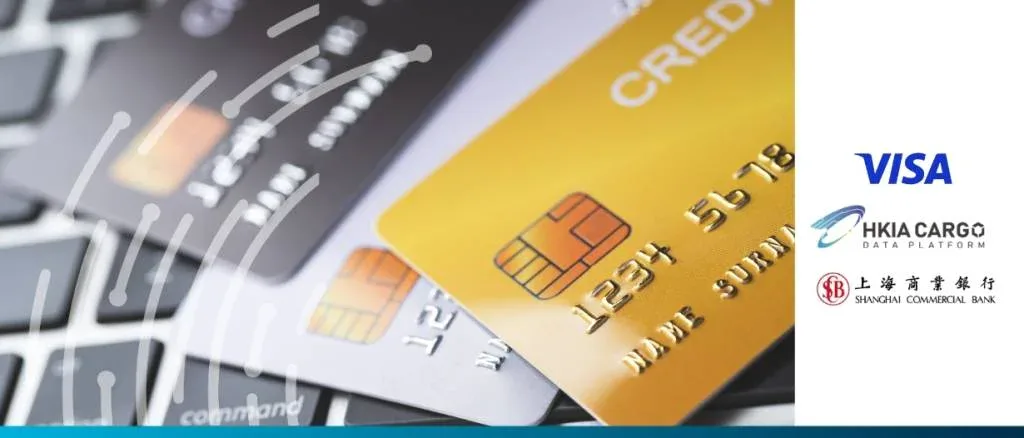Close-up of credit cards on a laptop keyboard featuring logos for Visa, HKIA Cargo, and Shanghai Commercial Bank, illustrating the digitalization of freight SME payments.