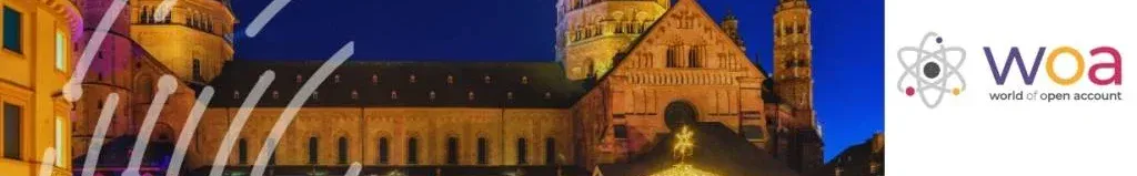 Night view of the illuminated Mainz Cathedral (Mainzer Dom) and a festive Christmas market with fairy lights in Mainz, Germany, for the WOA 4th Community Convention organized by World of Open Account.