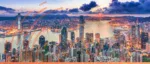 Sunset aerial view of the Hong Kong skyline and Victoria Harbour, representing the city