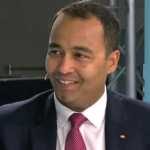 Business professional smiling at a trade finance event, showcasing global trade expertise and financ.