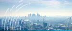 A hazy panoramic view of the London skyline and the River Thames at sunset, symbolizing the UK
